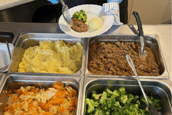 Meat & vegetables being served onto a plate